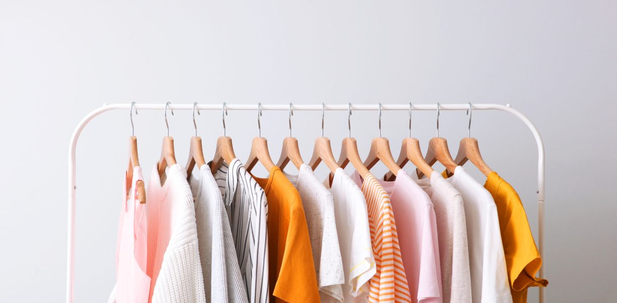 fashion clothes on a rack in a light background indoors. place for text